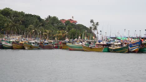 fishing boats docked closely at mirissa harbour, colorful, calm and tropical coast