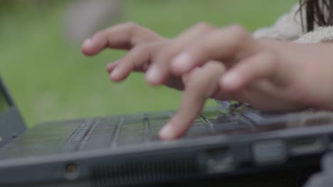 Toma-En-Cámara-Lenta-De-Una-Joven-Escribiendo-En-Un-Teclado-En-El-Jardín