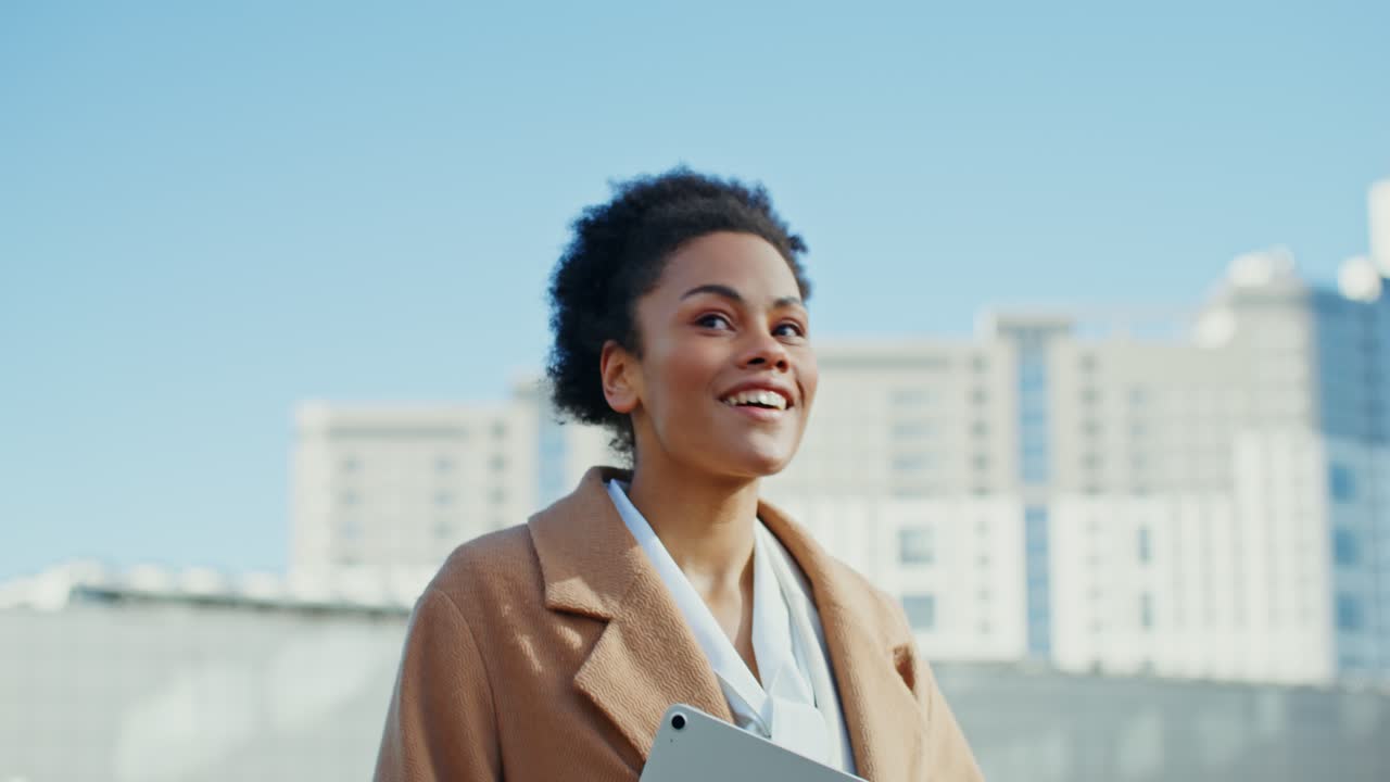 mujer sonriente caminando por la ciudad