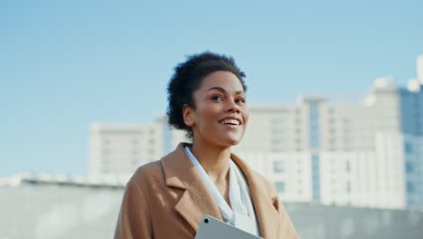 mujer sonriente caminando por la ciudad