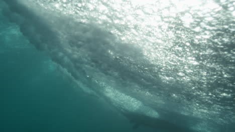Underwater vortex spinning below clean curling barrel, slow motion wave power captured