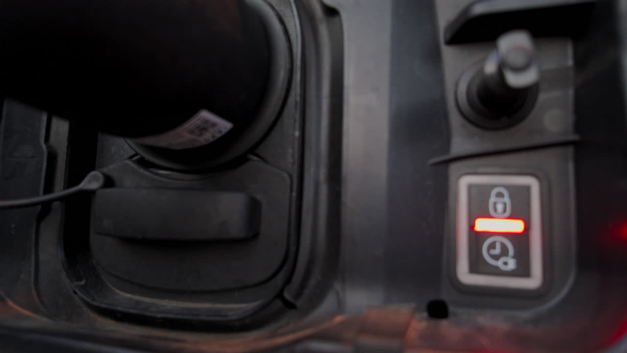 Close up of an electric vehicle charging connector with illuminated green indicator lights
