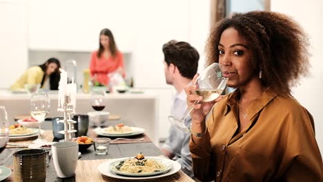 cheerful young black woman with wineglass at party