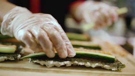 sushi chef preparing salmon cucumber sushi