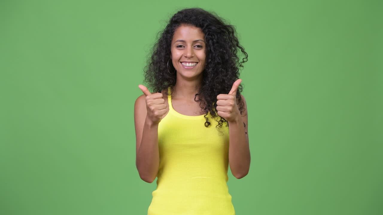 Young beautiful Hispanic woman giving thumbs up