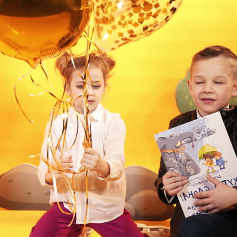 happy children with balloons on a yellow background in the studio. celebration and party. having fun. square video