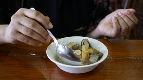 Women-eating-cooked-mushroom-on-table-,