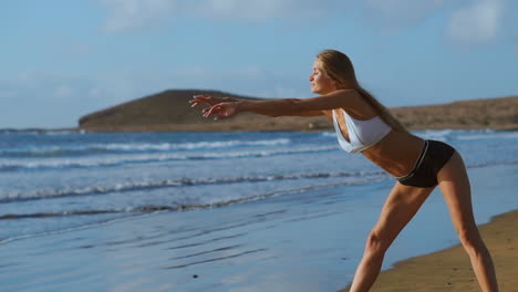 Woman-stretching-legs-and-hamstrings-doing-Standing-Forward-Bend-Yoga-stretch-pose-on-beach.-Fitness-woman-relaxing-and-practising-sport-and-yoga-on.