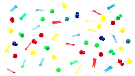 stop motion animation timelapse of colorful color push pins thumb tacks top view seamless loop on white background