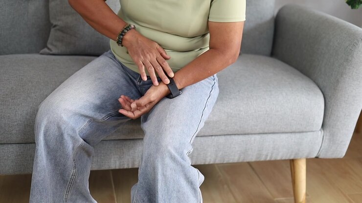 Senior Asian woman using smartwatch fitness tracker for health monitoring at home
