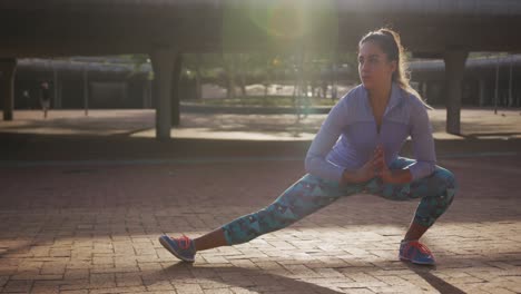 mujer caucásica estirándose en un parque
