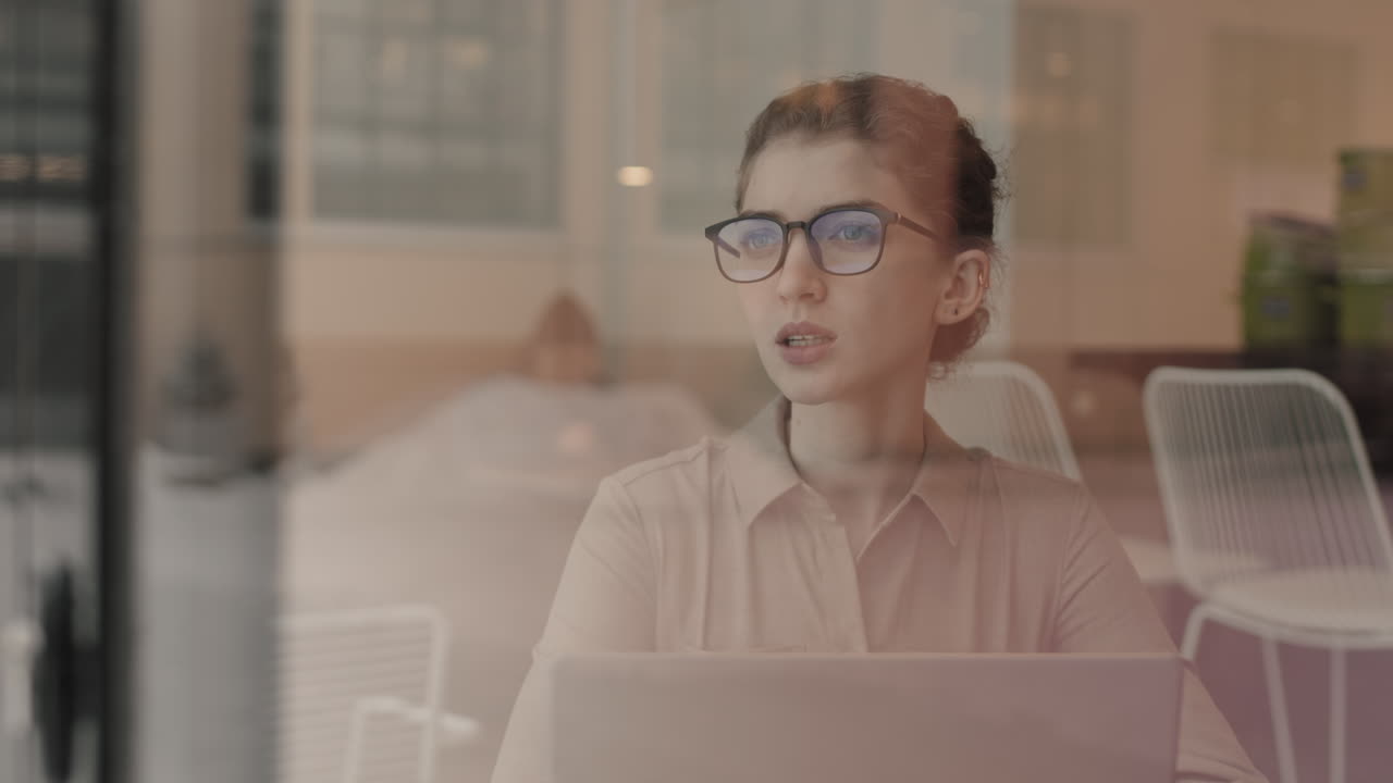 mujer joven trabajando en una computadora portátil en un café