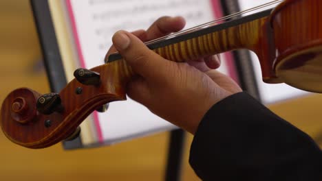 cinematic shot of a white person playing a violin with note sheets in the background, shot on fx30 in 4k