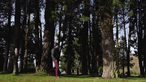 stylish camper walking through a large pine forest