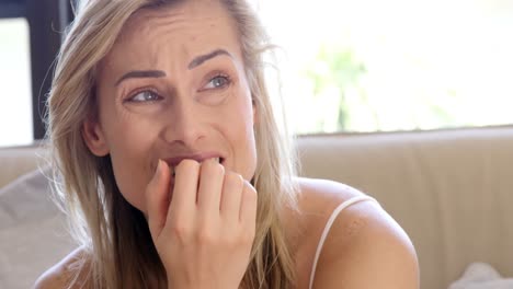 Seated-women-crying-while-eating-her-nail