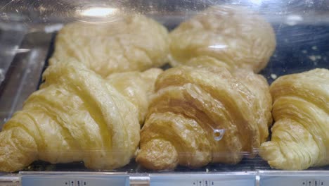 close-up of freshly baked croissants on display in a bakery