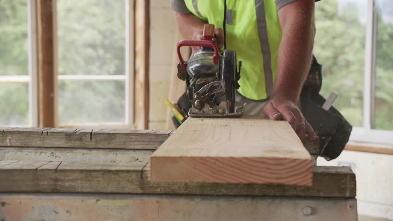 Closeup of construction worker cutting with circular saw