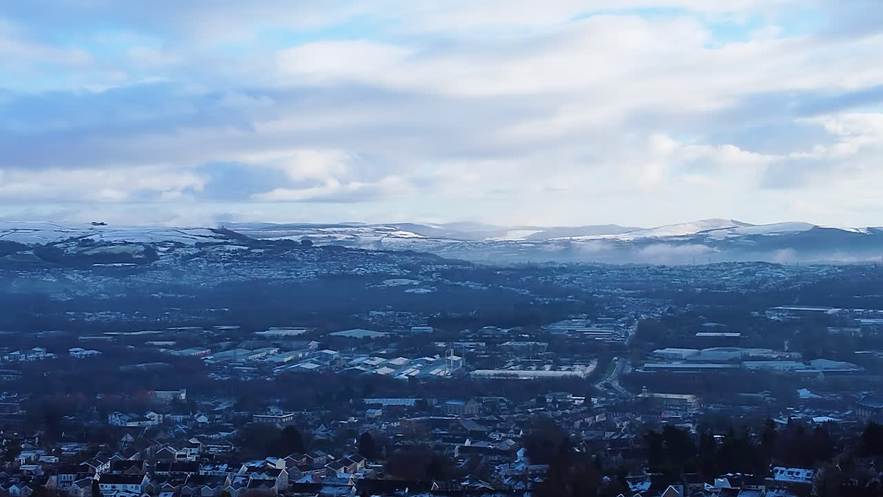 Storslået luftfoto af Swansea-dalen om vinteren, der viser sneklædte bakker med spredte huse og industriområder. 4K drone, høj kontrast sæsonbestemte optagelser