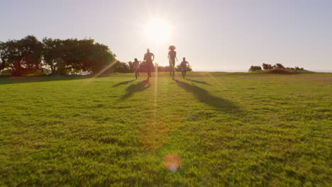 Young-black-family-running-towards-moving-camera-in-a-park