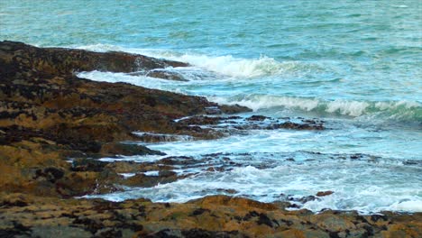 Slow-motion-static-shot-of-waves-crashing-off-rocks-in-Ireland-on-a-windy-day