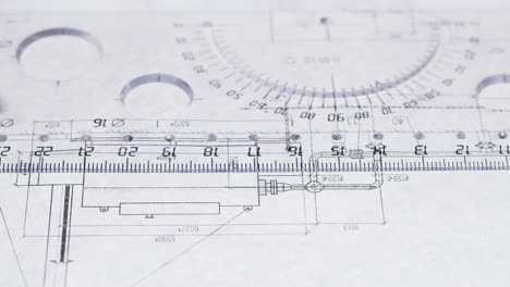close-up of a hand using a ruler and pen on a technical drawing or blueprint