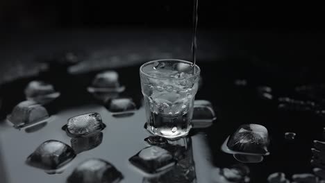 pouring vodka into a shot glass with ice