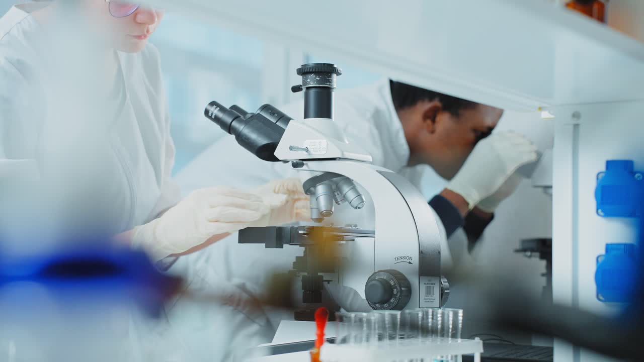 científicos que usan microscopios en un laboratorio