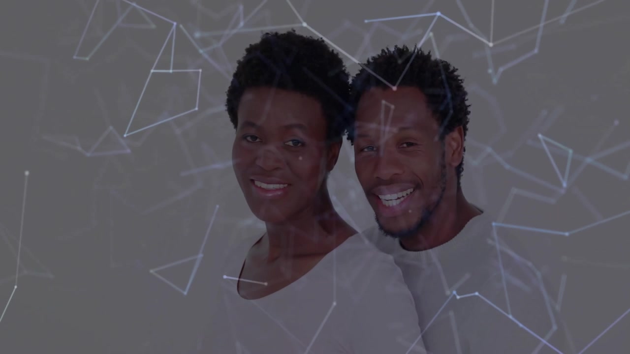 Donna e uomo in piedi su uno sfondo da studio grigio chiaro, che mostrano una sovrapposizione luminosa di tecnologia di rete.