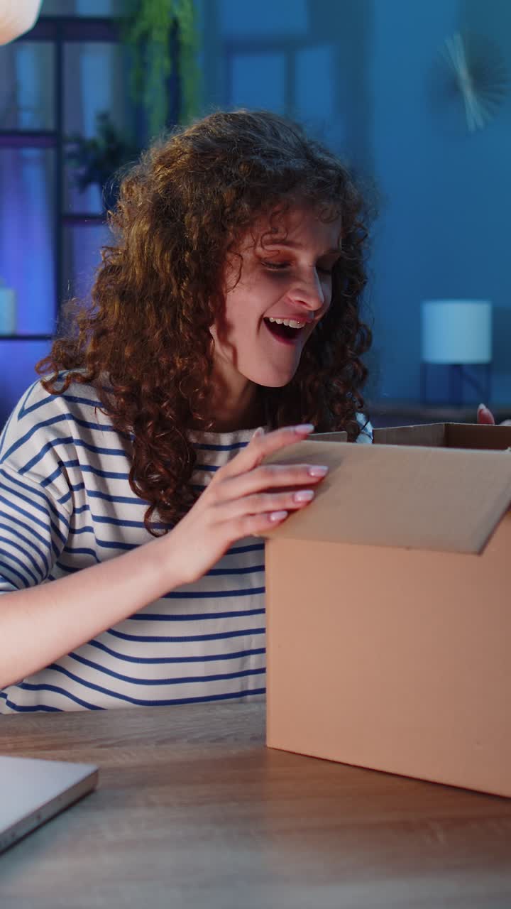 Feliz joven compradora desempaquetando cajas de cartón entrega de paquetes compras en línea compra en casa