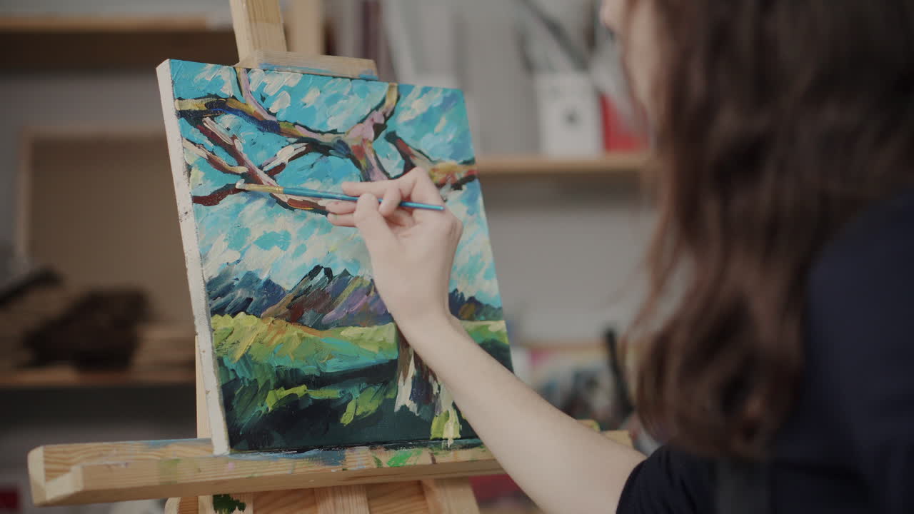 una mujer pintando un paisaje.