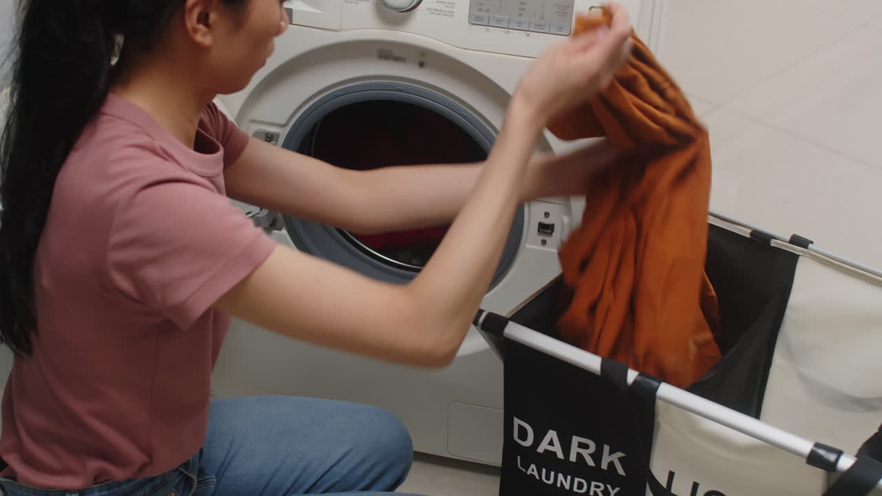 Girl Sorting Dark and Light Laundry and Loading Washing Machine