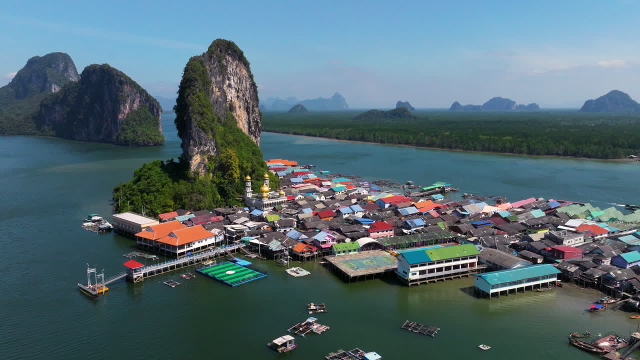 Floating Fishing Village of Koh Panyee With Pier And Limestone Island In Summer In Phang Nga Bay, Thailand. - aerial shot