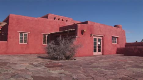 an adobe house occupies a desert plain in new mexico