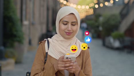 muslim woman walking along city street looking at mobile phone with motion graphics emojis showing multiple networking messaging and social media notifications