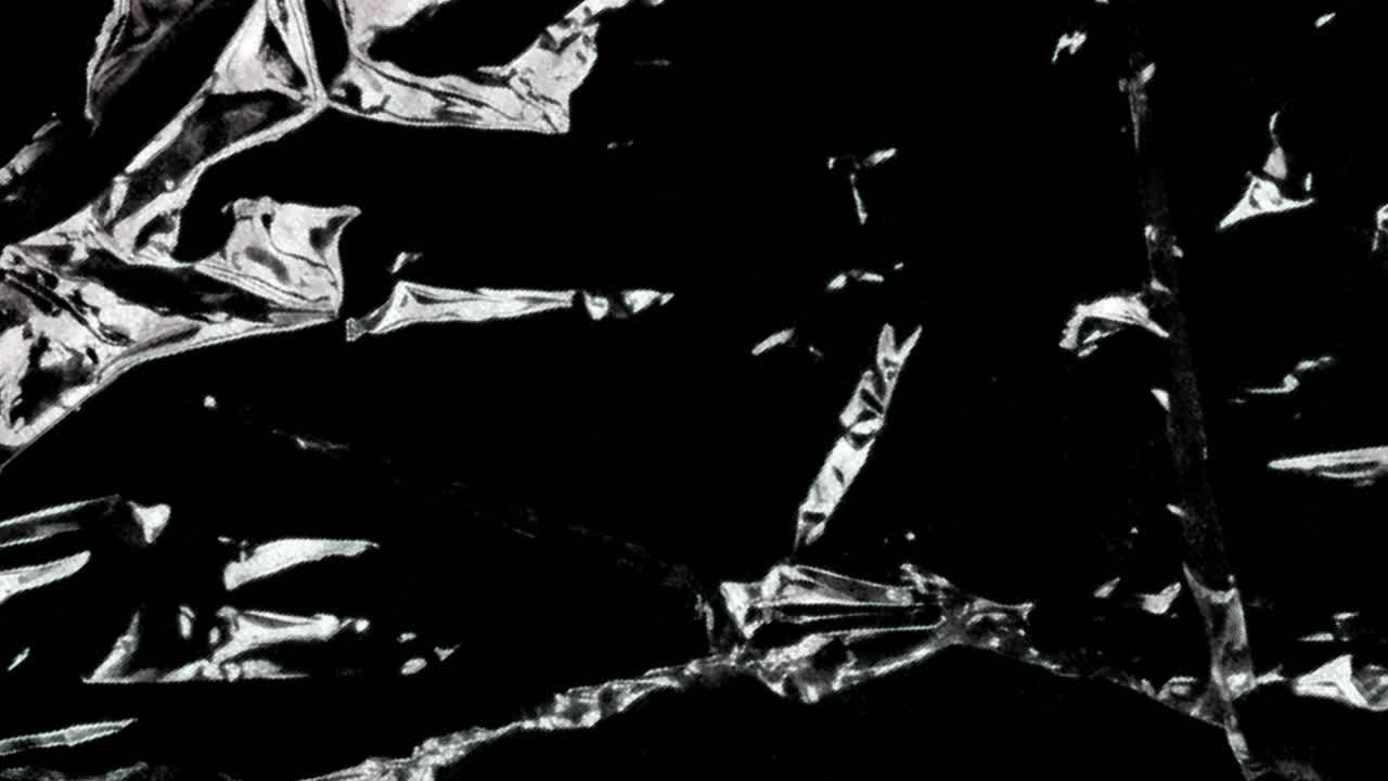 Filme Plástico Transparente Amassado Abstrato Movendo-se em Fundo Preto