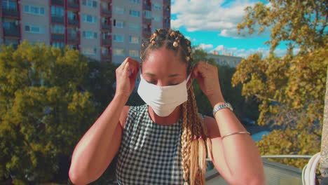 feliz responsable mujer de raza mixta poniendo fask al aire libre durante el brote pandémico del virus covid 19