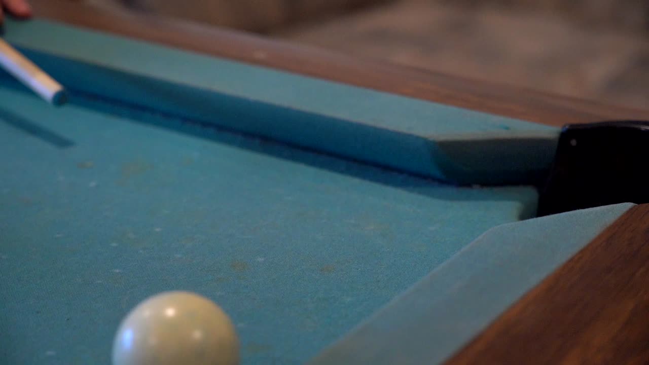 una toma en cámara lenta de la bola blanca golpeando la bola rayada 15 en la tronera