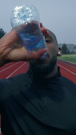 athlete drinking water on track