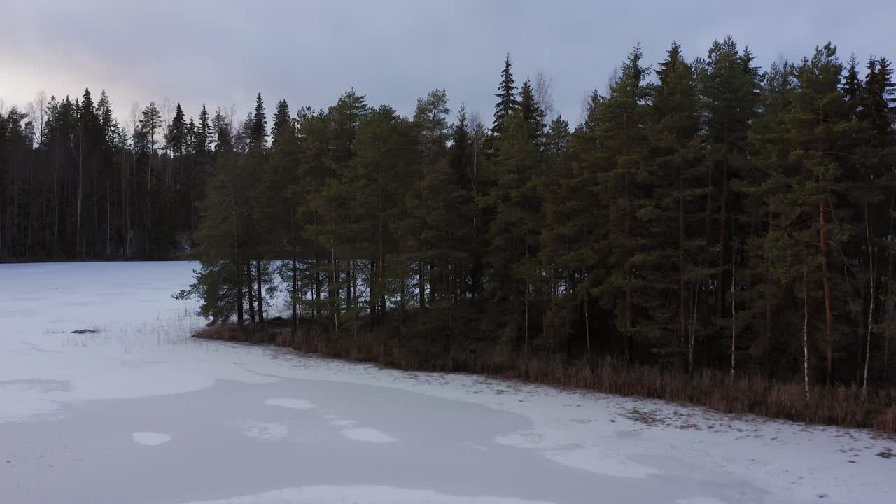 Ilmakuva jäätyneestä järvestä moottoritien vieressä Suomessa