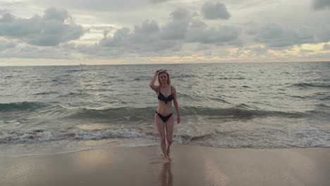 Una-Joven-Rubia-Atractiva-Caminando-Desde-El-Océano-Sobre-La-Playa