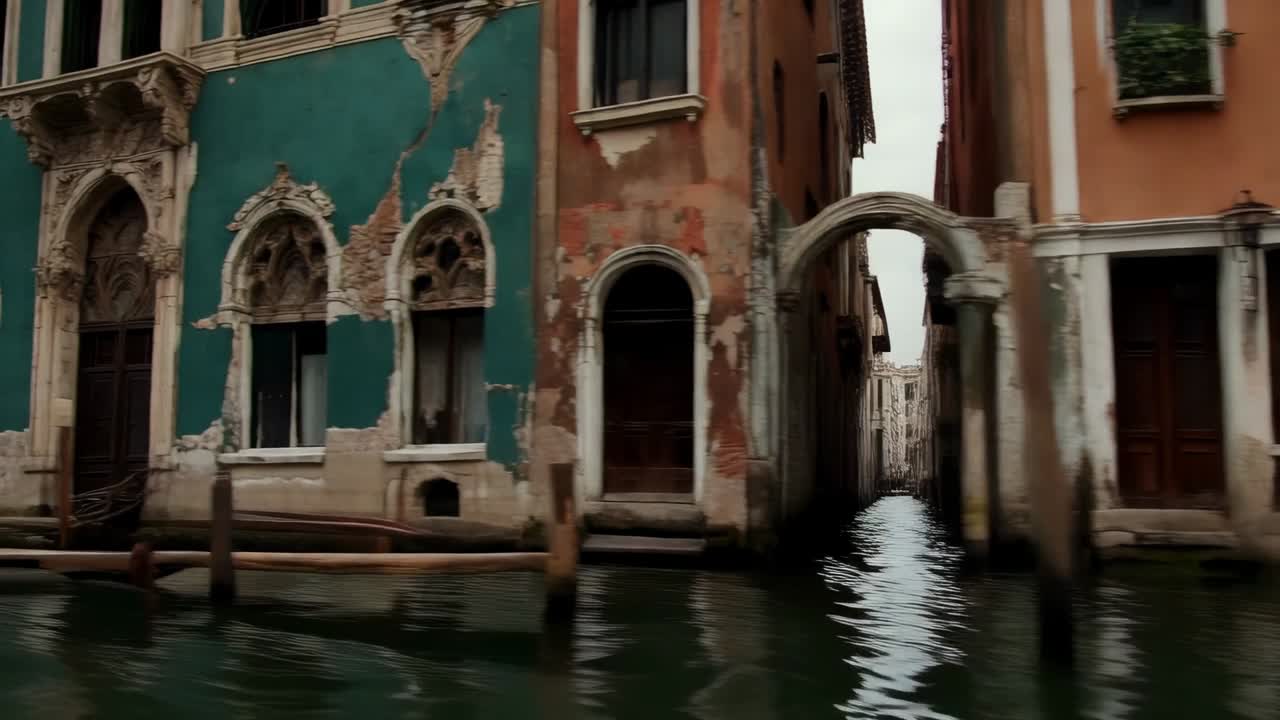 Prua di motoscafo in planata, motore in funzione che rivela un'elaborata facciata verde acqua lungo il canale, con gondole