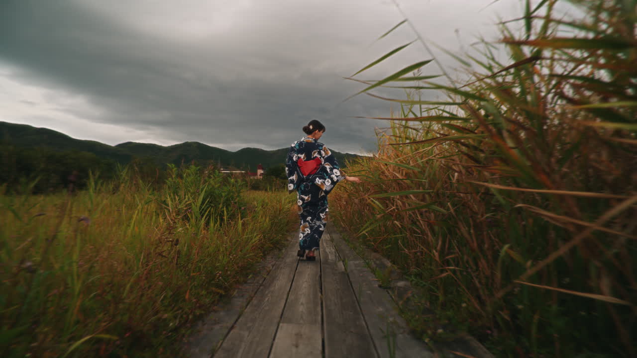 Woman in Kimono Walking on Wooden Path
