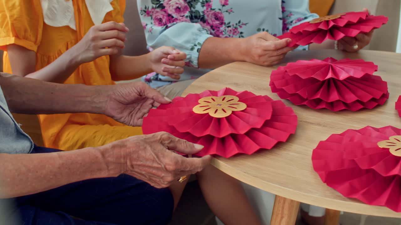 Grandparents and Teenage Girl Discussing Lunar New Year Decorations
