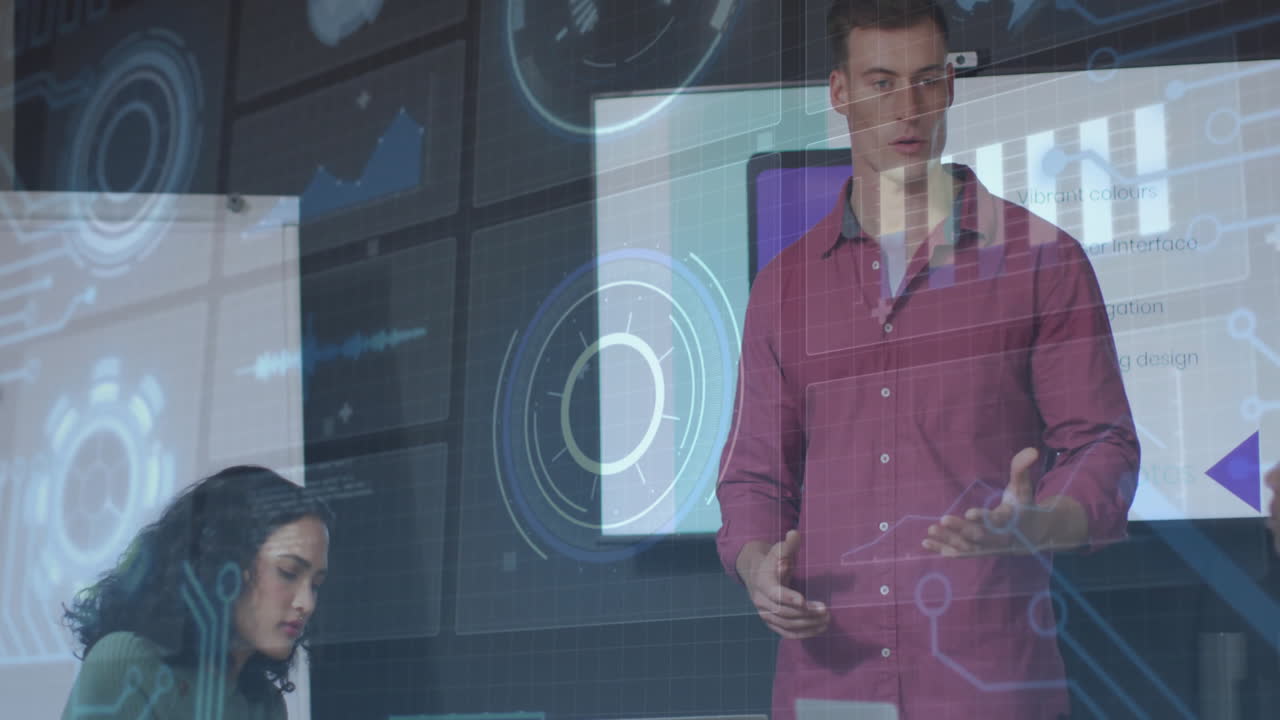 Man presenting while woman working on laptop in business meeting, showing digital charts overlay