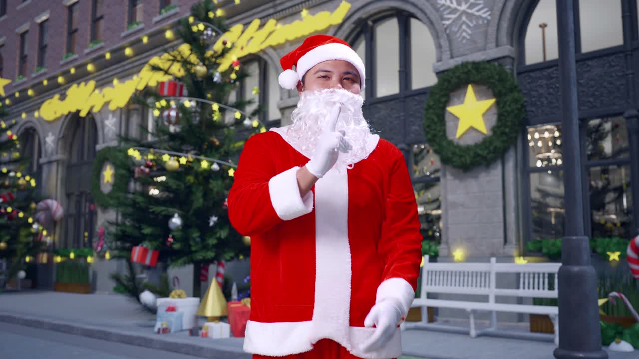 아시안 산타클로스가 손가락으로 총을 겨누고 카메라를 향해 총을 는 모습, 크리스마스 밤에 무기 제스처로 선택하는 모습