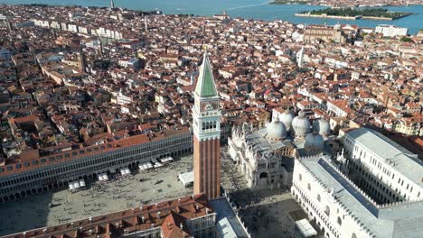Panoramic aerial view of St. Mark's Square, Campanile, and Venetian cityscape under clear skies.
