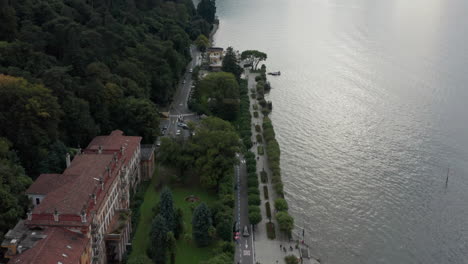 Beautiful-aerial-of-road-and-pier-next-to-Lake-Como,-Italy