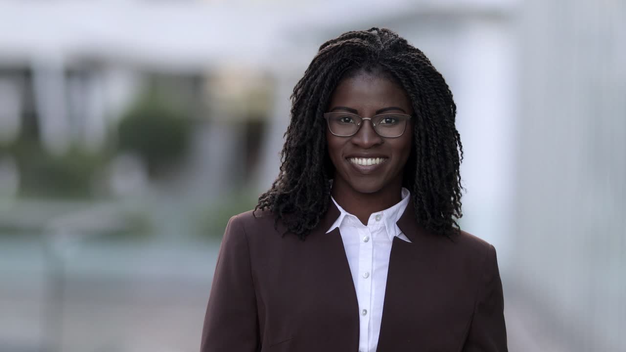 vista frontal de una mujer sonriente con rastas mirando a la cámara