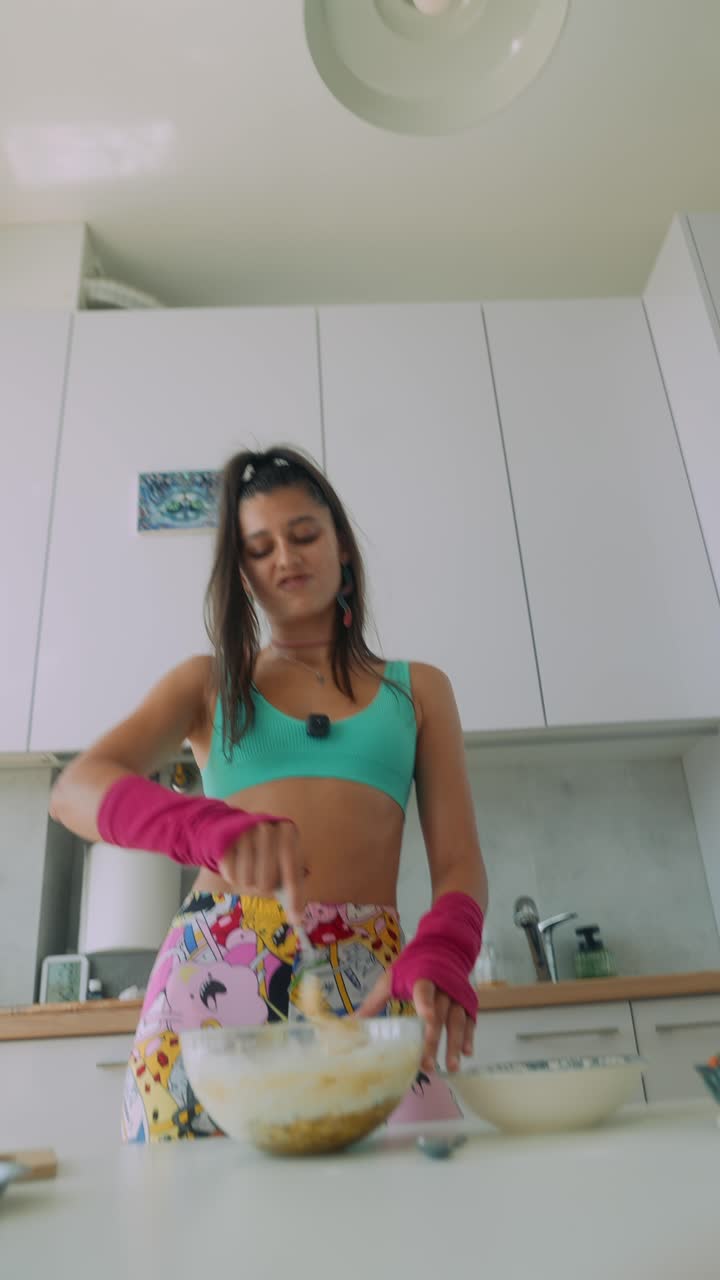 Giovane donna che mescola ingredienti in una ciotola in una cucina moderna