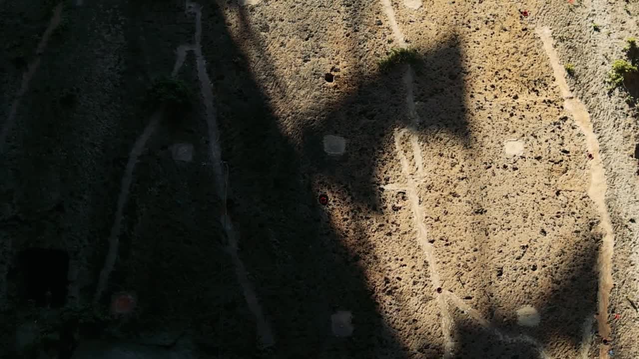 A dynamic shadow shifts across a textured stone wall, revealing intricate patterns and natural contrasts.